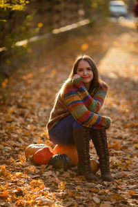 Portrait of young woman sitting on rock