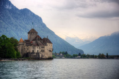 Scenic view of lake by buildings against sky