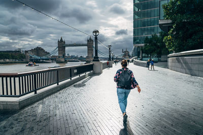 Rear view of woman walking on bridge