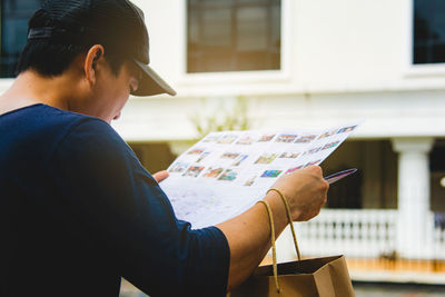 Side view of man reading book