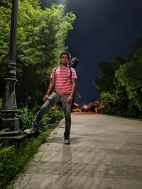 Full length of young man standing against trees