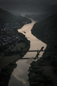 High angle view of river amidst silhouette trees against sky