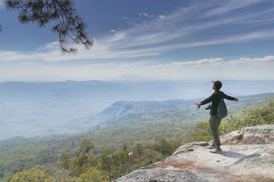 Man standing on rock looking at mountains