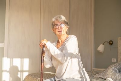 Portrait of senior woman sitting on bed at home