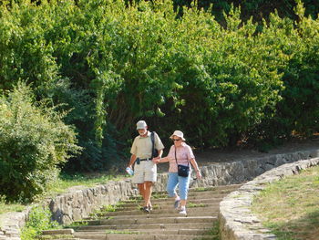 Senior couple walking on steps against trees