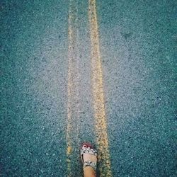 Low section of woman standing on road