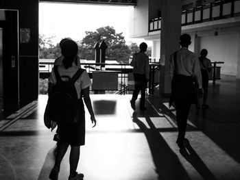 Rear view of students walking in university