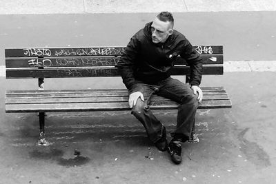 Full length of man sitting outdoors