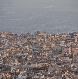 High angle view of townscape by sea against sky