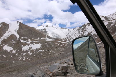 Scenic view of snowcapped mountains seen through car window