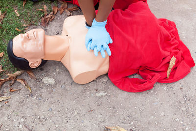 Midsection of paramedic performing cpr on mannequin