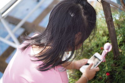 Close-up of girl taking picture of plants