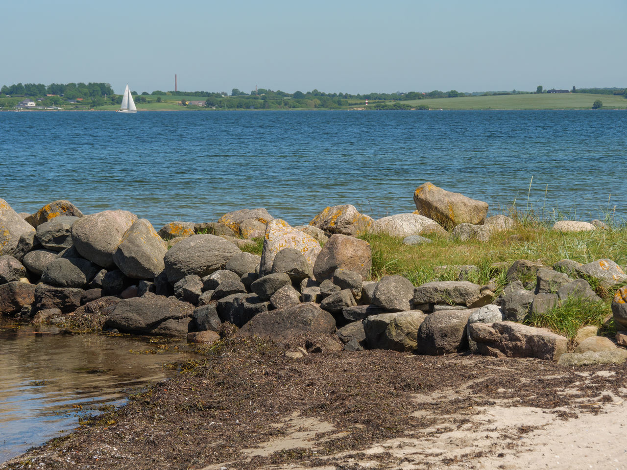 ROCKS ON SHORE AGAINST CLEAR SKY