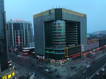 Traffic on city street amidst buildings against sky