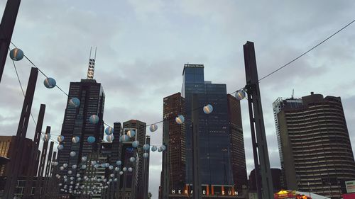 Low angle view of skyscrapers against cloudy sky