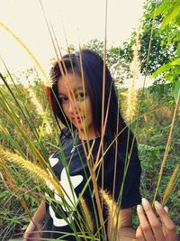 Close-up of young woman holding grass