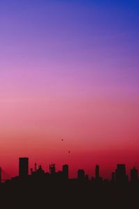 Silhouette buildings against sky during sunset