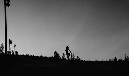 Silhouette of trees on landscape against clear sky