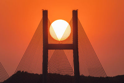 Low angle view of bridge against orange sky