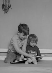 Close-up of boy sitting on floor at home