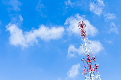 Low angle view of communications tower against blue sky