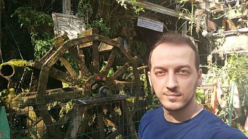 Portrait of young man standing against plants