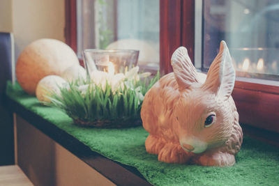 Close-up of easter bunny on table by window at home