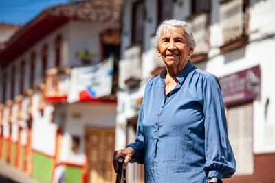 Portrait of young woman standing in city