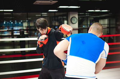 Men practicing in boxing ring