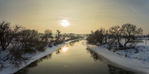 Scenic view of frozen lake against sky during sunset