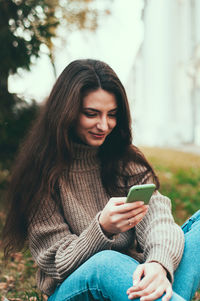 Young woman using mobile phone outdoors