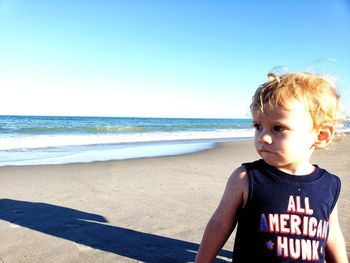 Boy at beach against sky