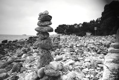 Stack of stones on beach against sky