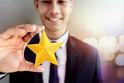 Close-up of smiling businessman holding star