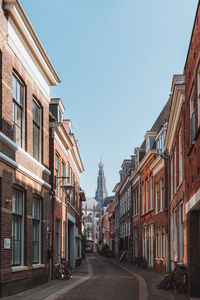 Street amidst buildings against clear sky