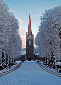 Facade of church with snow covered trees during winter