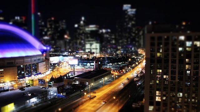 illuminated, city, night, building exterior, architecture, built structure, transportation, light trail, motion, city life, long exposure, blurred motion, street, speed, traffic, road, cityscape, car, mode of transport, on the move