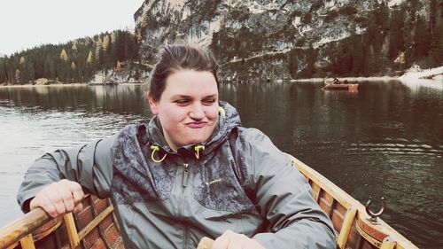 Young woman sitting on rowboat in lake