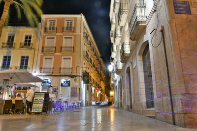 Street amidst buildings in city at night