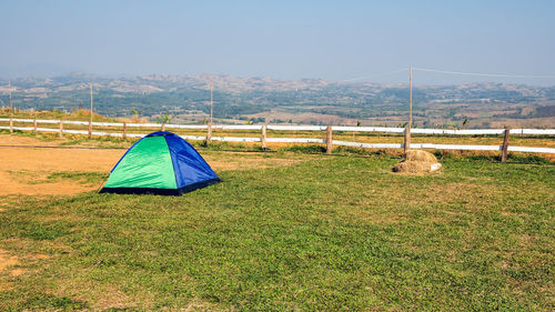 Tent on field by mountain against sky