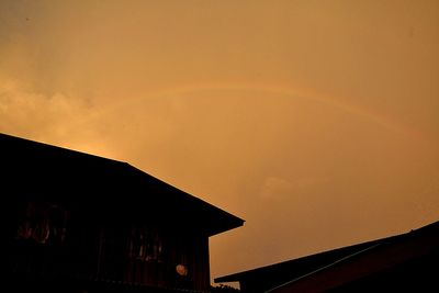 Low angle view of silhouette house against sky during sunset