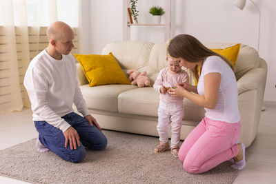 Rear view of woman sitting on bed at home