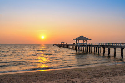 Pier on sea against sky during sunset