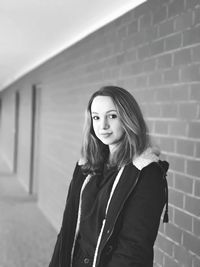 Portrait of woman standing against wall