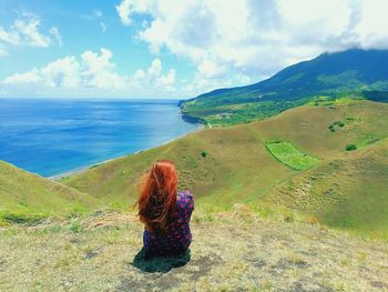 Rear view of woman looking at sea against sky