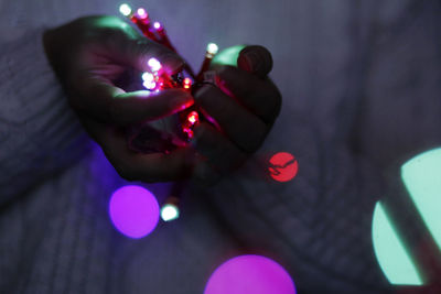 Close-up of woman hand holding multi colored lights