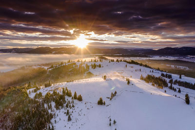 Scenic view of snowcapped mountains against sky during sunset