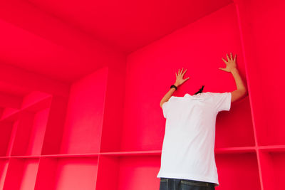 Man standing against red wall