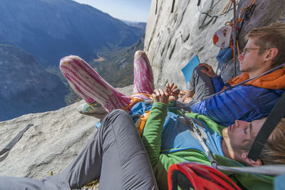 Two climbers resting on a ledge in the shade on el capitan, yosemite