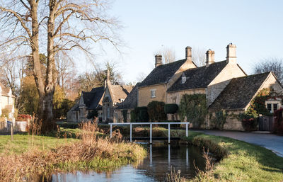 Houses by river against clear sky